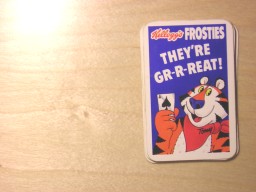 A badly taken photograph of some Kelloggs Frosties playing cards placed face down as a group on a table